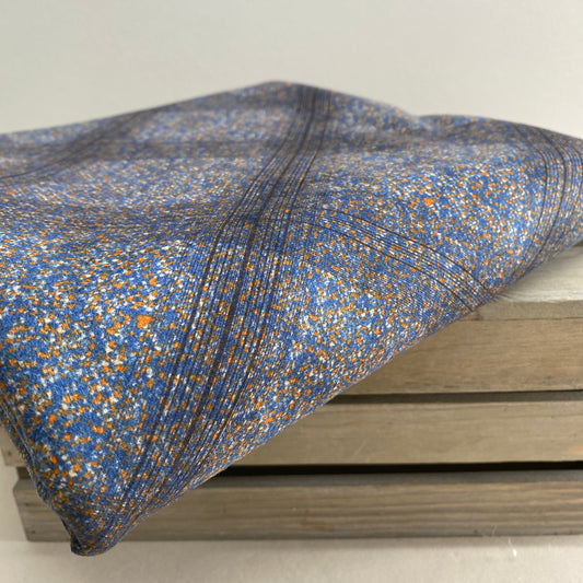 Textured blue and gold fabric draped over a wooden frame against a white background